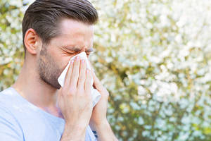 Homme allergique qui éternue